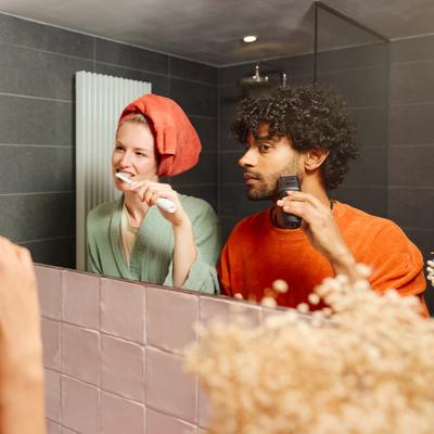 Un couple devant le miroir de la salle de bains