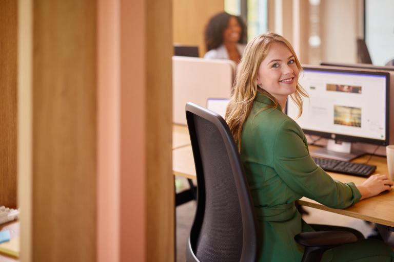 Lachende Eneco werknemer achter haar bureau