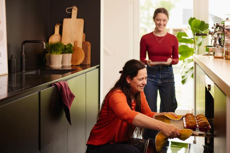 Vrouw haalt koekjes uit de oven