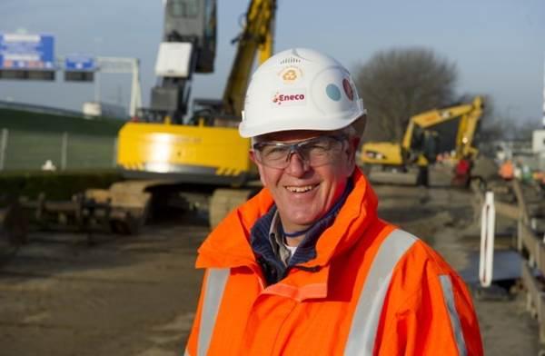 Man in oranje vest en helm