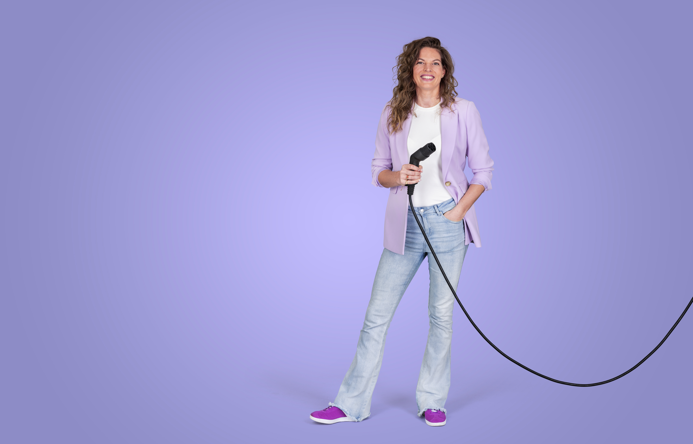 vrouw met laadkabel in haar hand