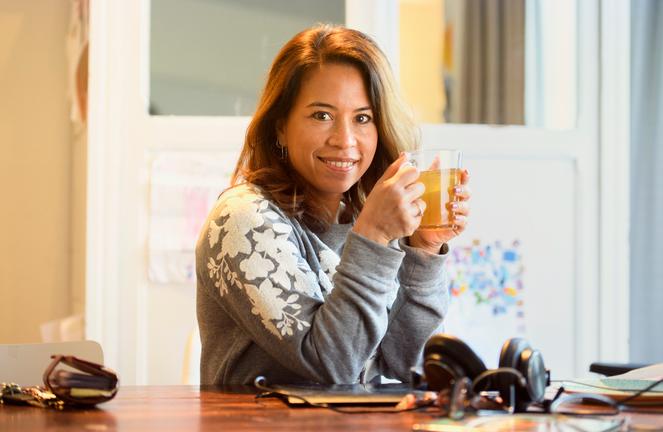 Jonge vrouw met een kop thee in de hand