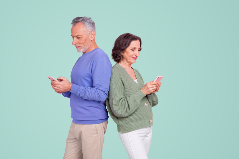 Vieux couple regardant leur téléphone