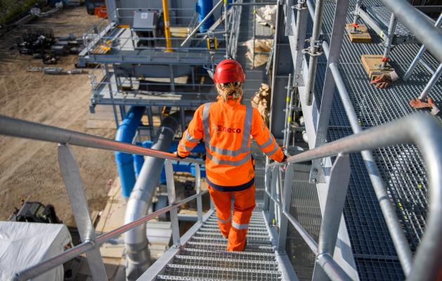 Eneco technieker industriële veiligheid bouwplaats metalen trap veiligheidskleding