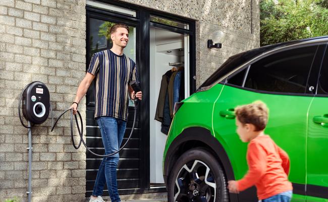 Een meneer gaat zijn elektrische auto opladen met een laadpaal van Eneco E-mobility