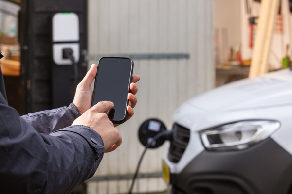 Een monteur bekijkt de status van het laden van zijn elektrische bedrijfswagen 