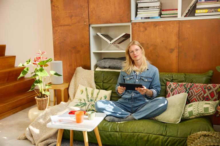 vrouw op de bank kijkt op haar tablet