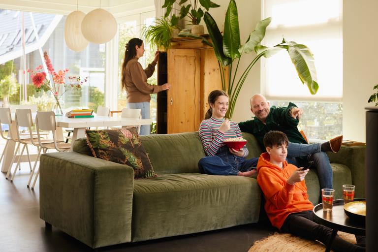 Een gezin kijkt samen op de bank naar de tv