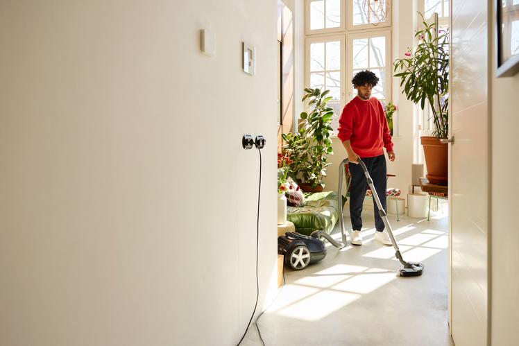 Man stofzuigt het huis