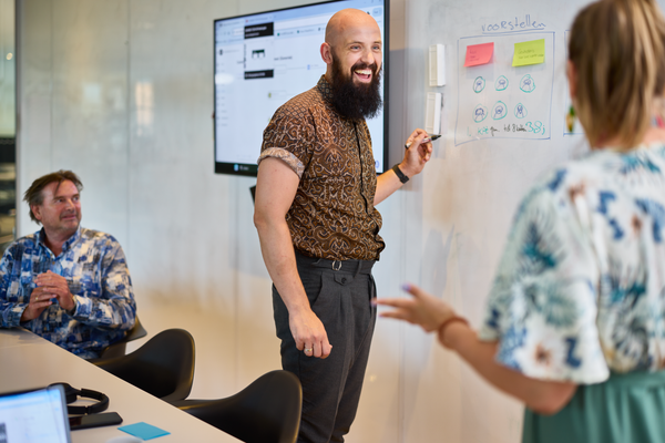 Lachende man schrijft op een whiteboard