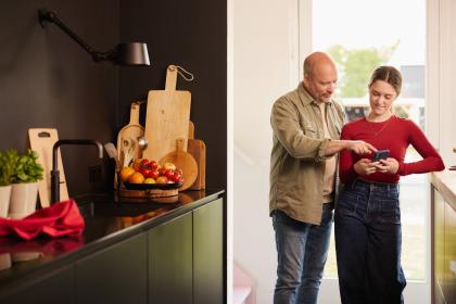 Vader toont dochter iets op de smartphone