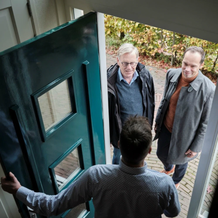 Twee mannen voor de deur van een bewoner