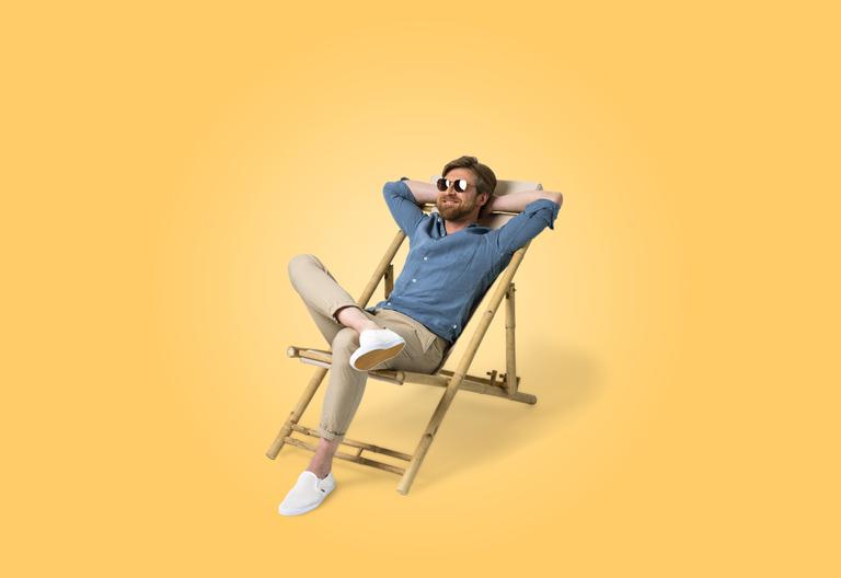 Un homme avec des lunettes de soleil se détend sur une chaise de plage