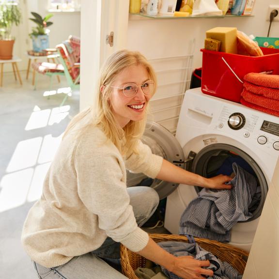 Vrouw doet was in wasmachine