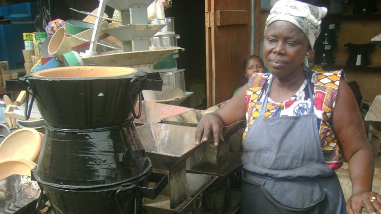 Ghanese vrouw kijkt naar traditionele kookpot