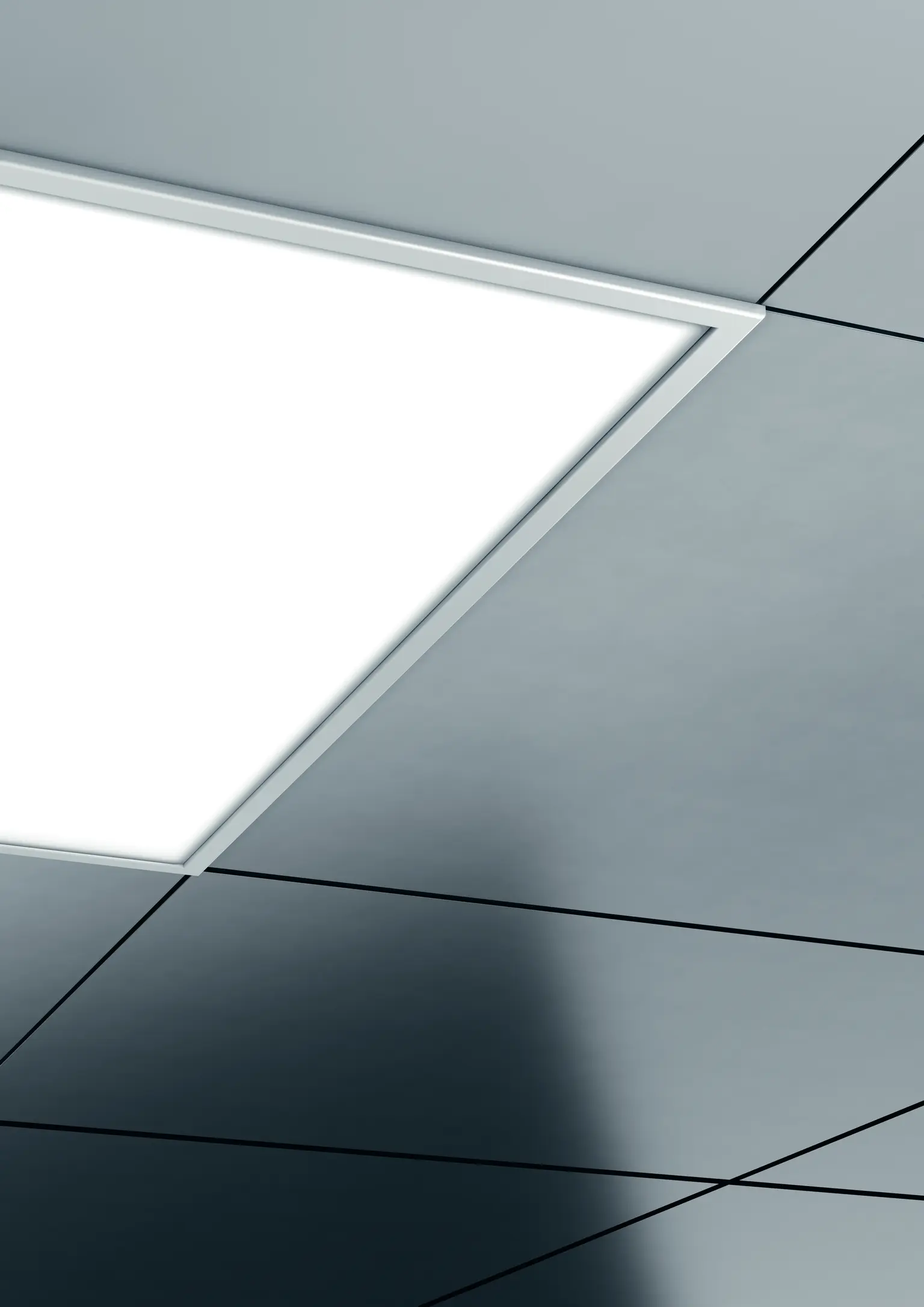 Eine CLEAN II Einbauleuchte an einer dunklen Decke sorgt für gleichmäßige, blendfreie Beleuchtung in einem modernen Indoor-Raum.