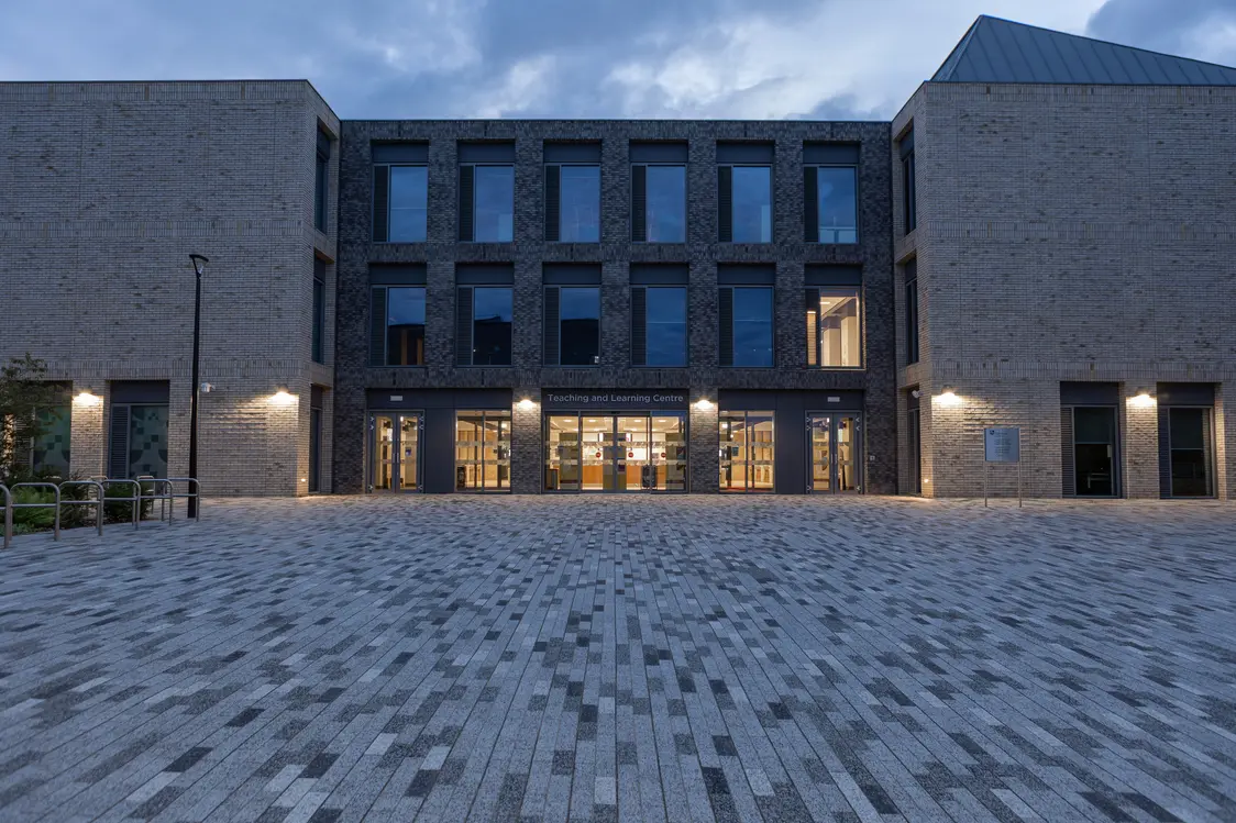 Zona di passaggio esterna di un campus universitario con illuminazione soffusa