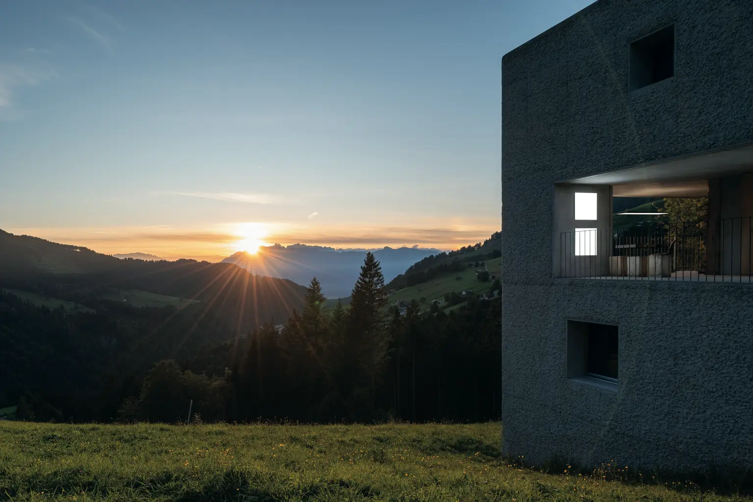 Tramonto sulle Alpi con un edificio moderno in primo piano, Zumtobel