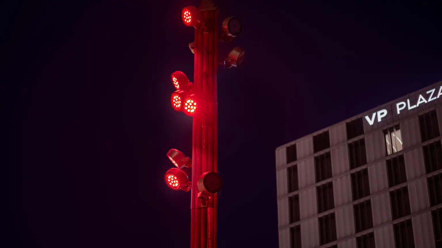 I faretti LED rossi sul palo offrono un'illuminazione d'accento dinamica, aggiungendo un elemento visivo colorato e mettendo in risalto le caratteristiche architettoniche nell'ambiente urbano.
