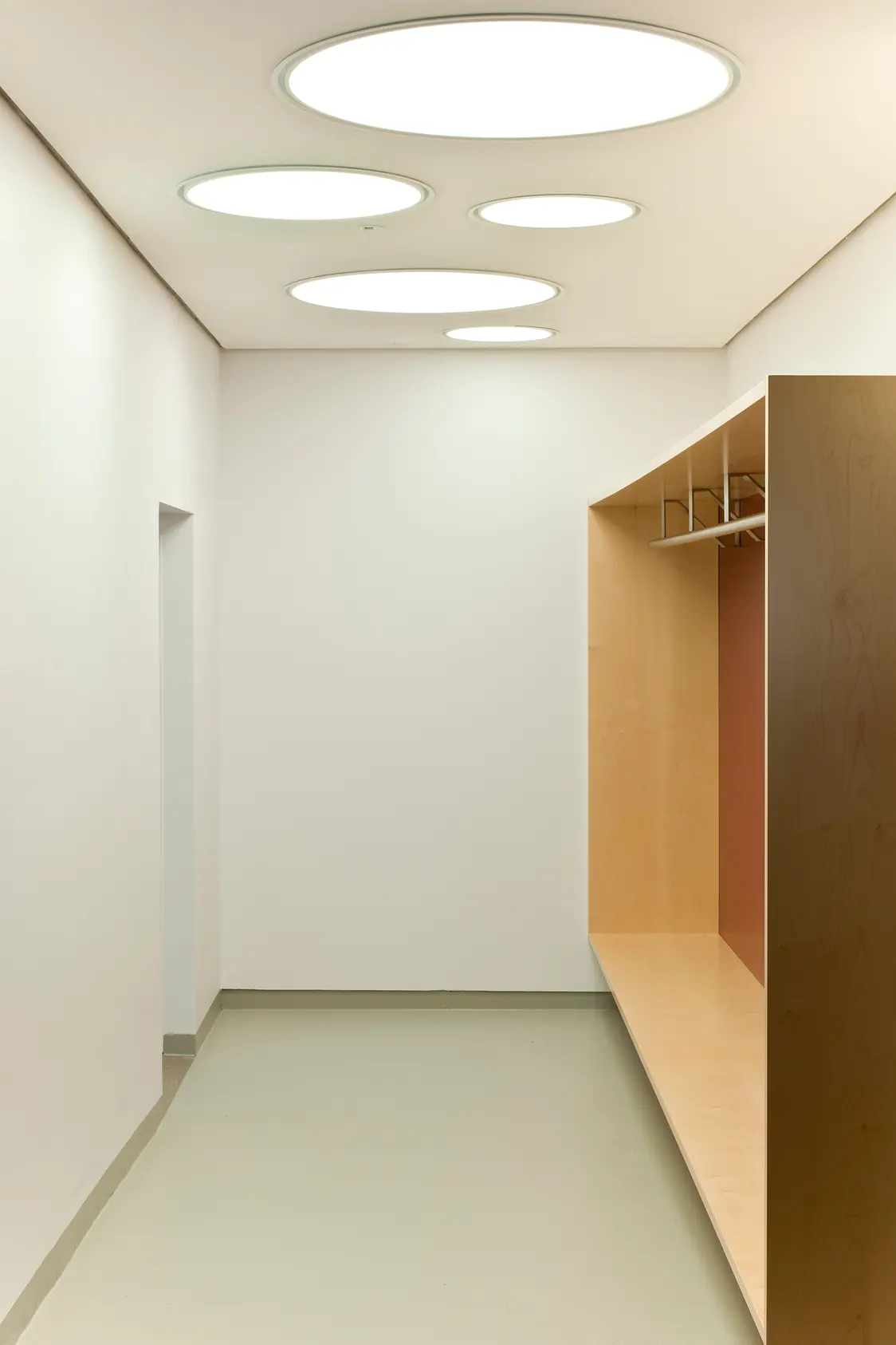 ONDARIA II Leuchten sorgen für gleichmäßige, blendfreie Beleuchtung in einem modernen Flur mit hellem Holzregal und weißen Wänden.