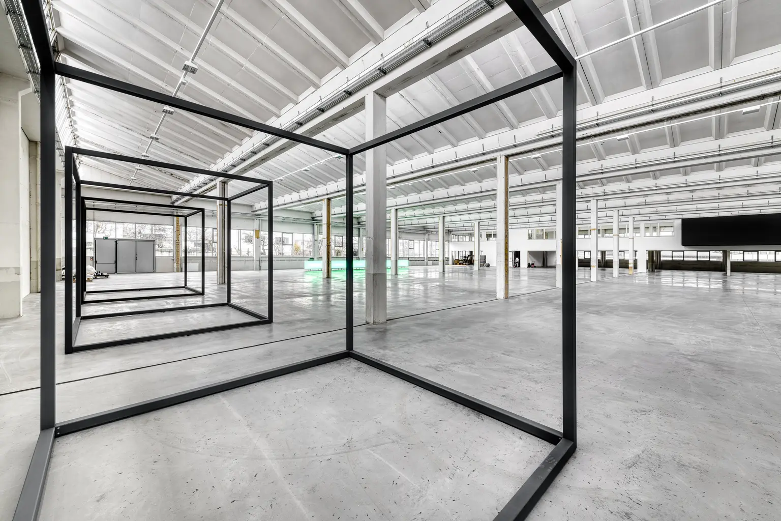 Große Halle mit klaren Linien und einer Metallkonstruktion. 