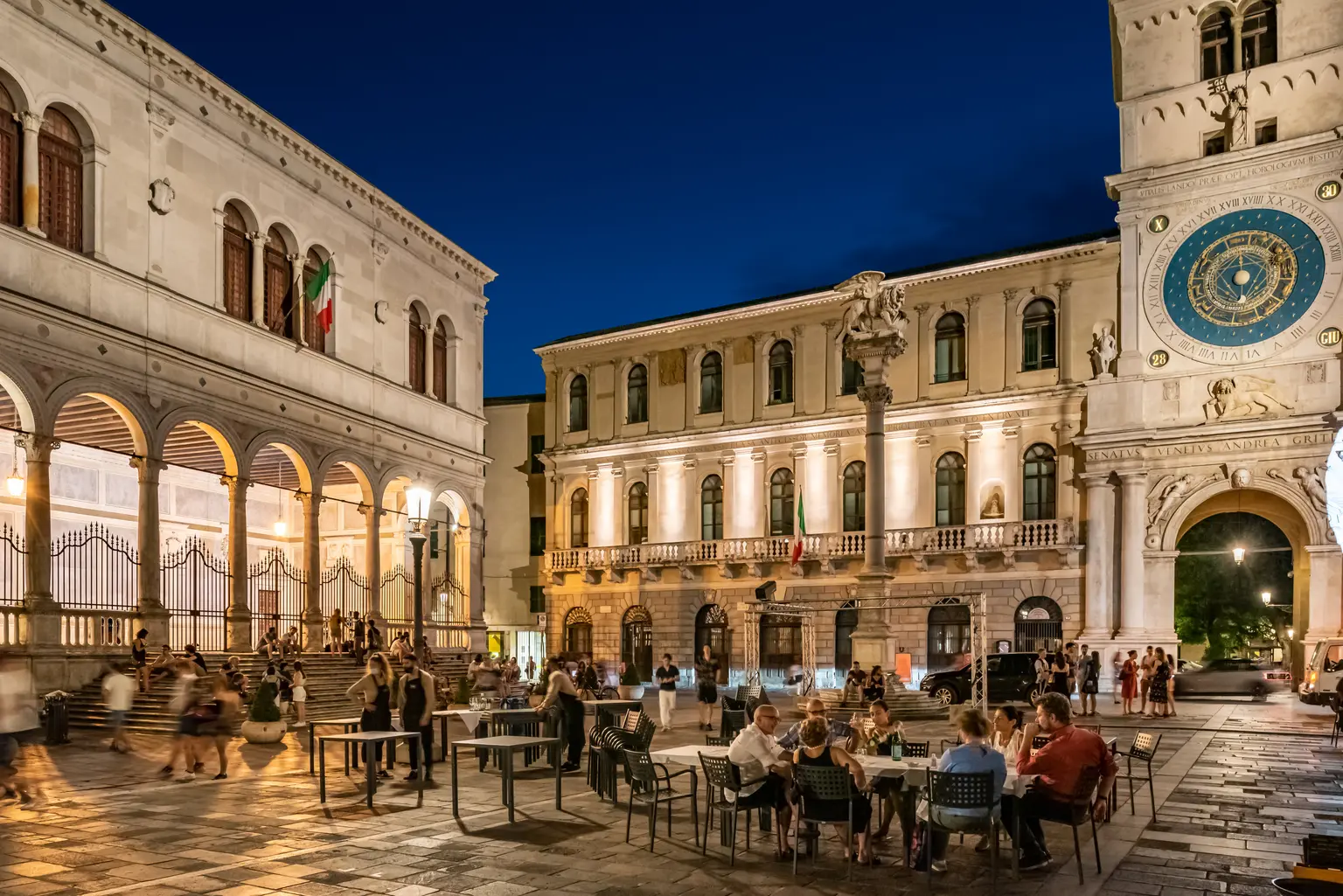 Palazzo Orologio Piazza di notte con persone che si godono lo spazio esterno