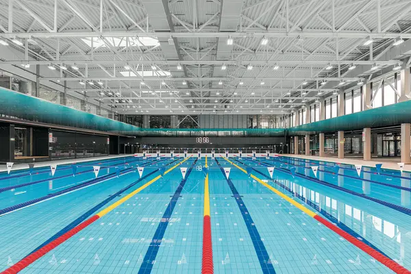 Piscina olimpionica al coperto, con luce naturale che entra