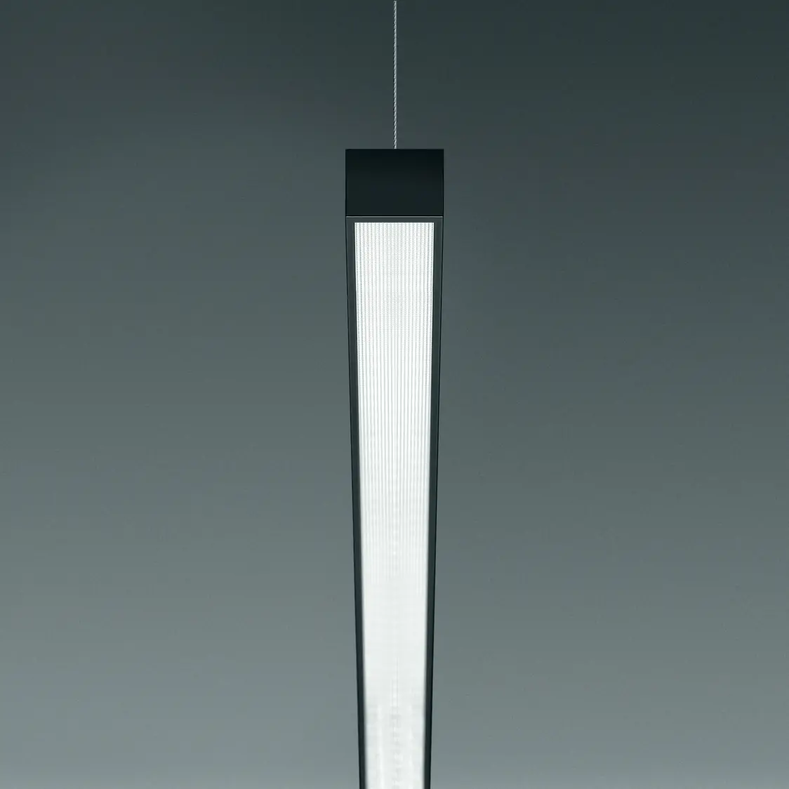 Die Supersystem Inline Hängeleuchte bietet gleichmäßige Beleuchtung in modernem Design vor einem neutralen Hintergrund.