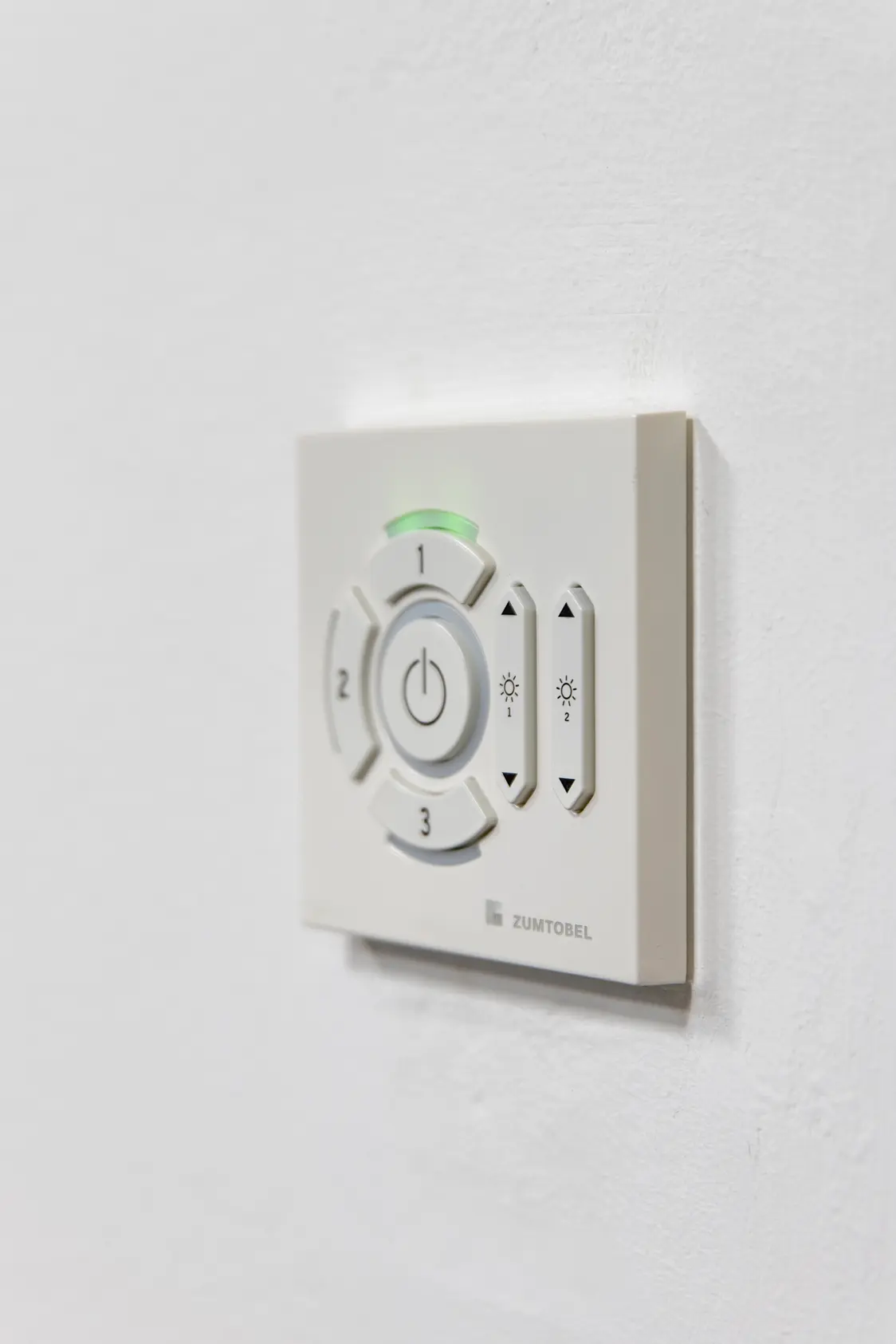 Eine weiße Circle Kit Lichtsteuerung hängt an einer weißen Wand.