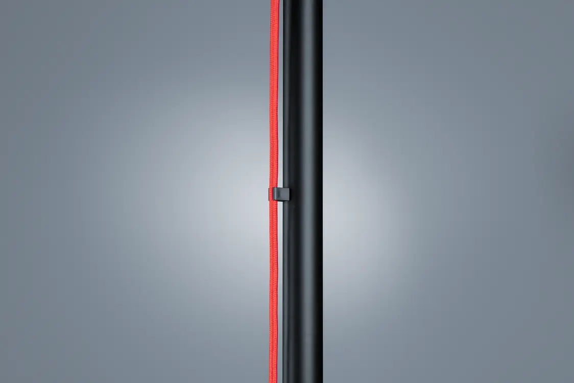 Die CANDILEA-Leuchte zeigt ein schlankes, schwarzes Design mit einem roten Element, das sich vertikal über die Länge erstreckt und einen modernen Akzent setzt.