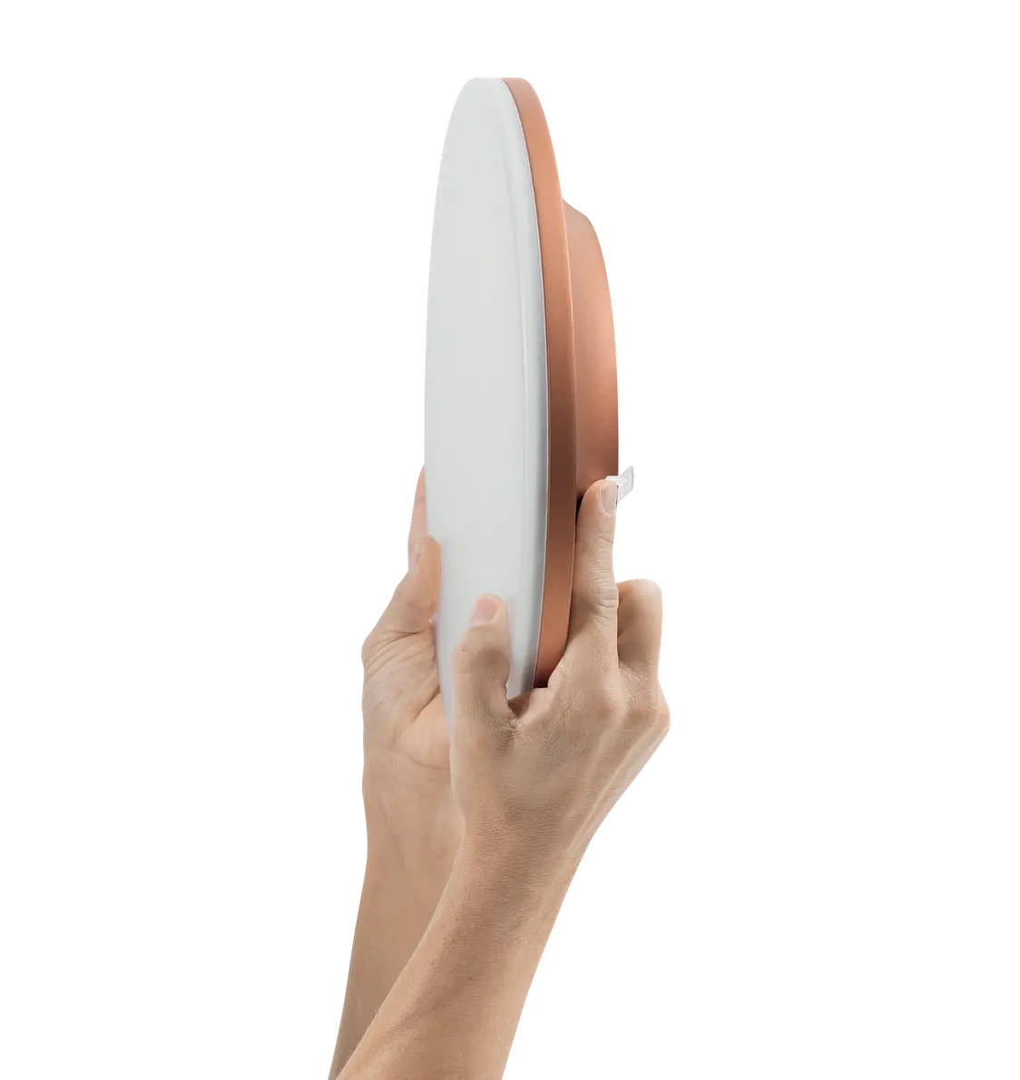 Die CAELA-Leuchte mit weißen und kupferfarbenen Elementen wird von zwei Händen präsentiert, um auf das schlanke und elegante Design hinzuweisen.