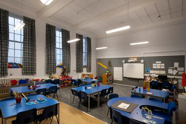 Aula di scuola primaria con luce naturale al crepuscolo e illuminazione lineare