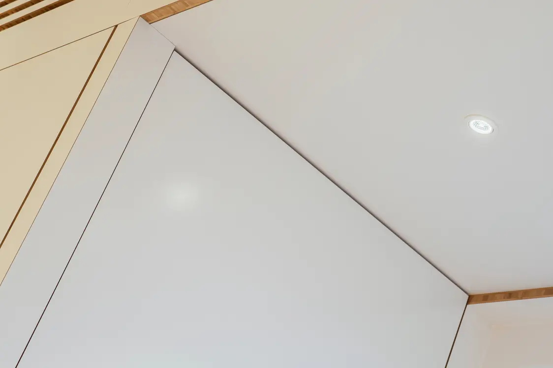 DIAMO LED-Spot beleuchtet gleichmäßig eine moderne Decke mit Holzakzenten und sorgt für klar definiertes Licht in einem schlichten Innenraum.
