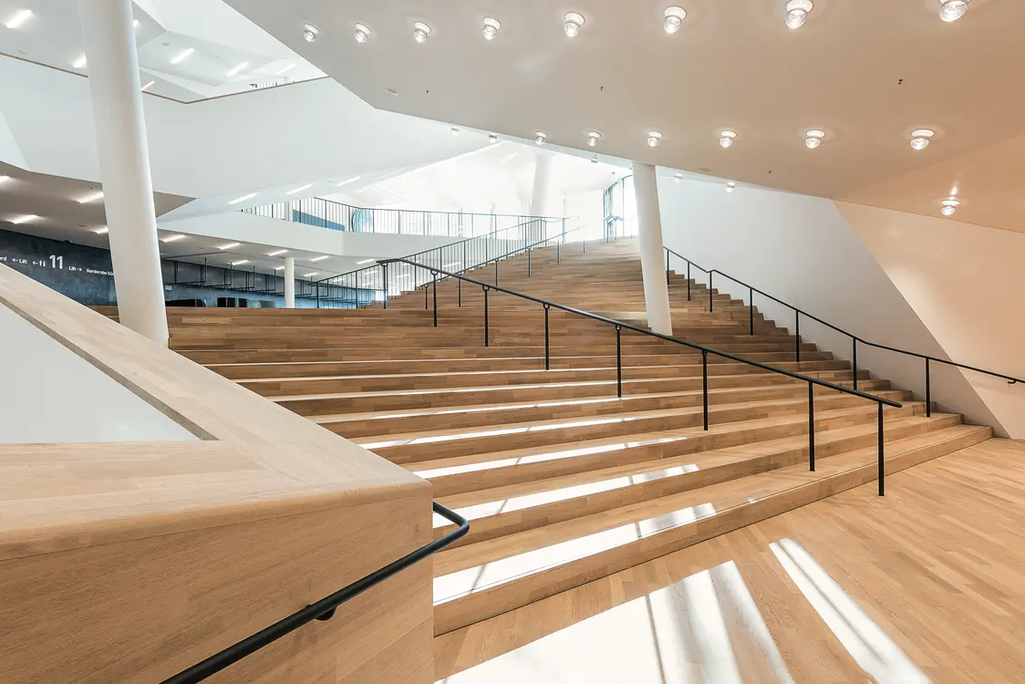 Heller Gang und Eingang zum Konzertsaal der Elbphilharmonie – stilvolle Architektur mit harmonischer Beleuchtungslösung von Zumtobel.