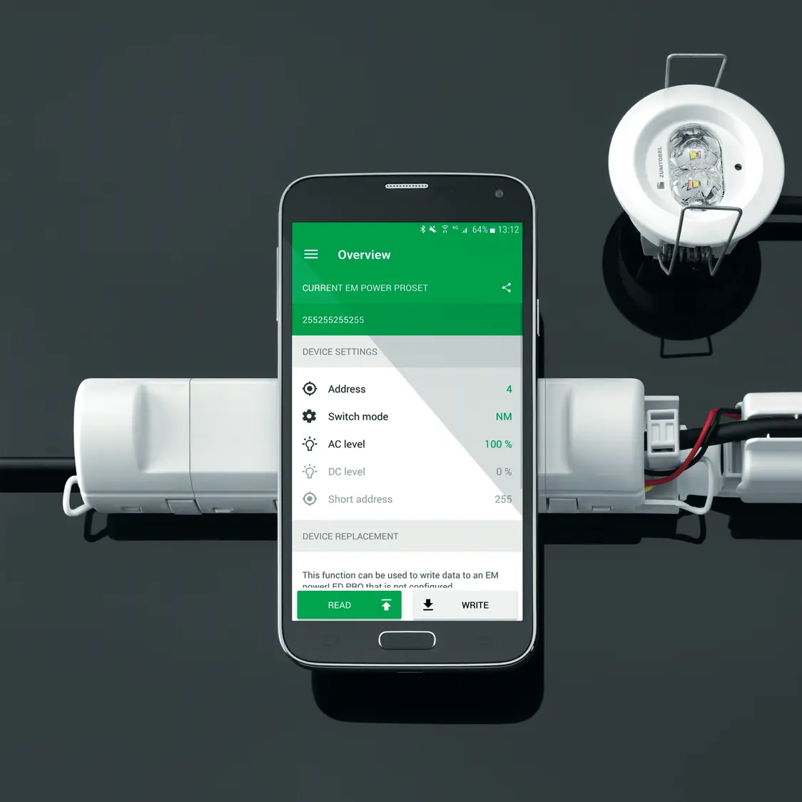 Un apparecchio illuminotecnico di emergenza RESCLITE PRO con un'app per smartphone per le impostazioni. 