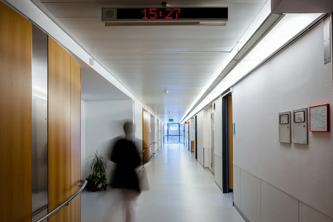 Moderner Krankenhausbereich mit Holzschränken, Waschbecken und grüner Lichtdecke im LKH Bruck an der Mur