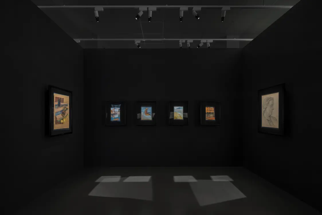 Hundertwasser Forum – precisely illuminated artworks in a dimly lit room, ranging from architecture to portraits.
