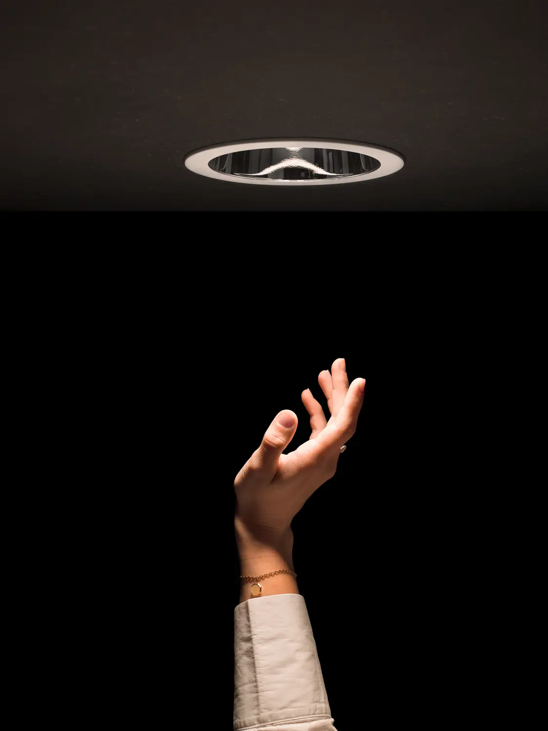 Bild von eingebauter PANOS III Leuchte und darunter ist eine Hand zu sehen