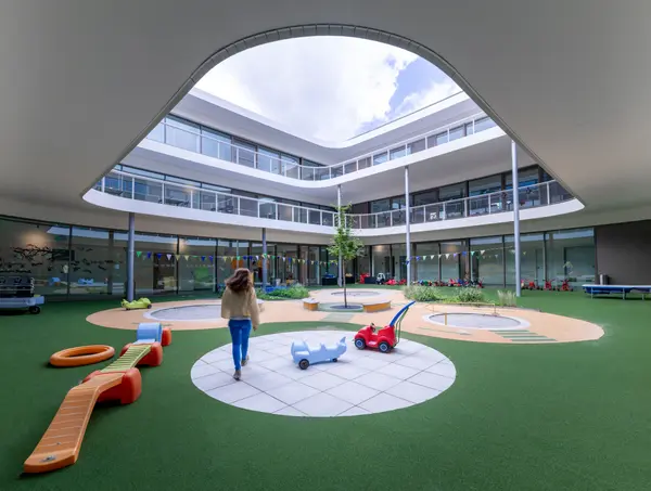 Cortile per bambini del MINT Care Campus con architettura ludica e illuminazione Zumtobel