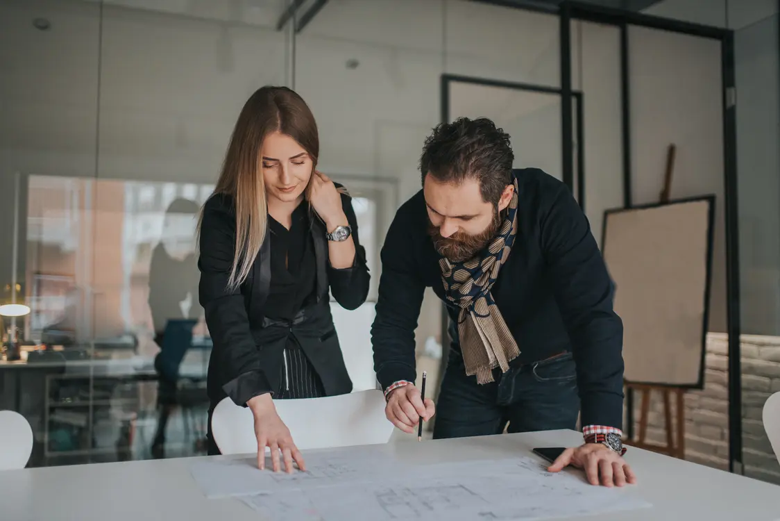 Due persone durante una consulenza sulla pianificazione strategica dell'illuminazione: sviluppo di soluzioni personalizzate con un focus su efficienza e sostenibilità. Zumtobel e Thorn Lighting.