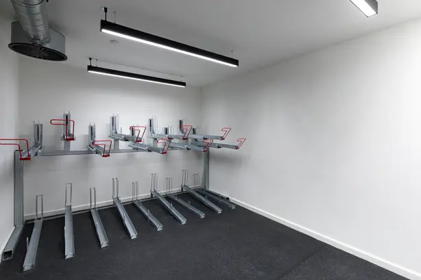A room for storing bicycles illuminated with two minimalist Slotlight Infinity luminaires from Zumtobel.
