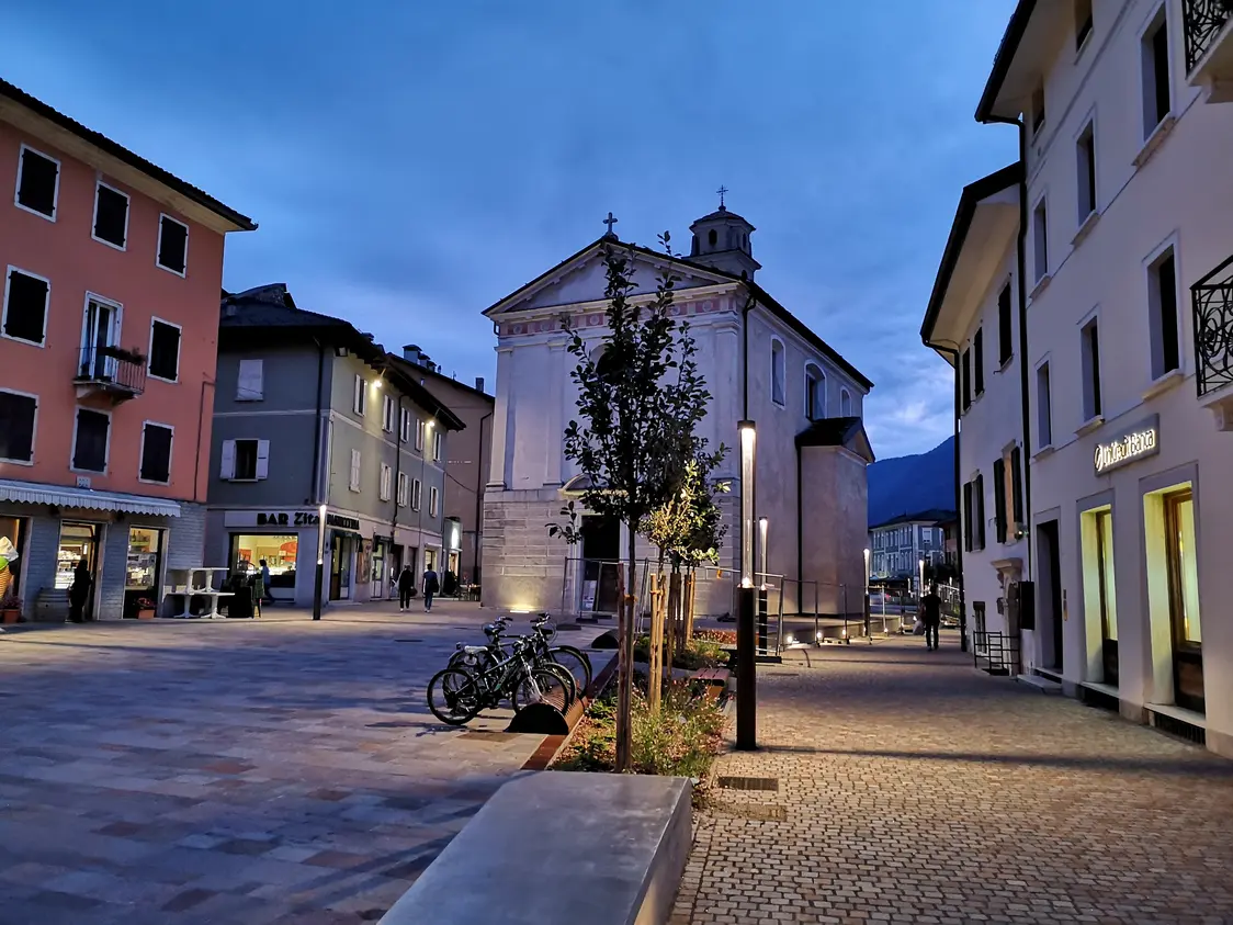 Una città di notte con un edificio storico sullo sfondo.