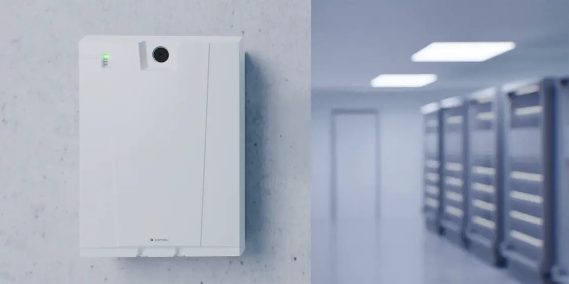  The ONLITE central nBOX is mounted on a concrete wall in a modern corridor, while LED lights evenly illuminate the corridor.