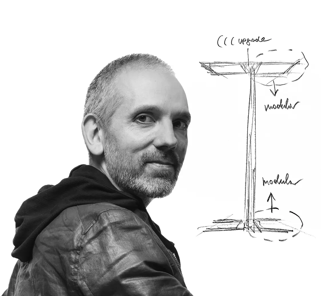 Il designer Harald Gründl con i disegni della leggendaria piantana ARTELEA. L'immagine è in bianco e nero e ha uno stile artistico. 
