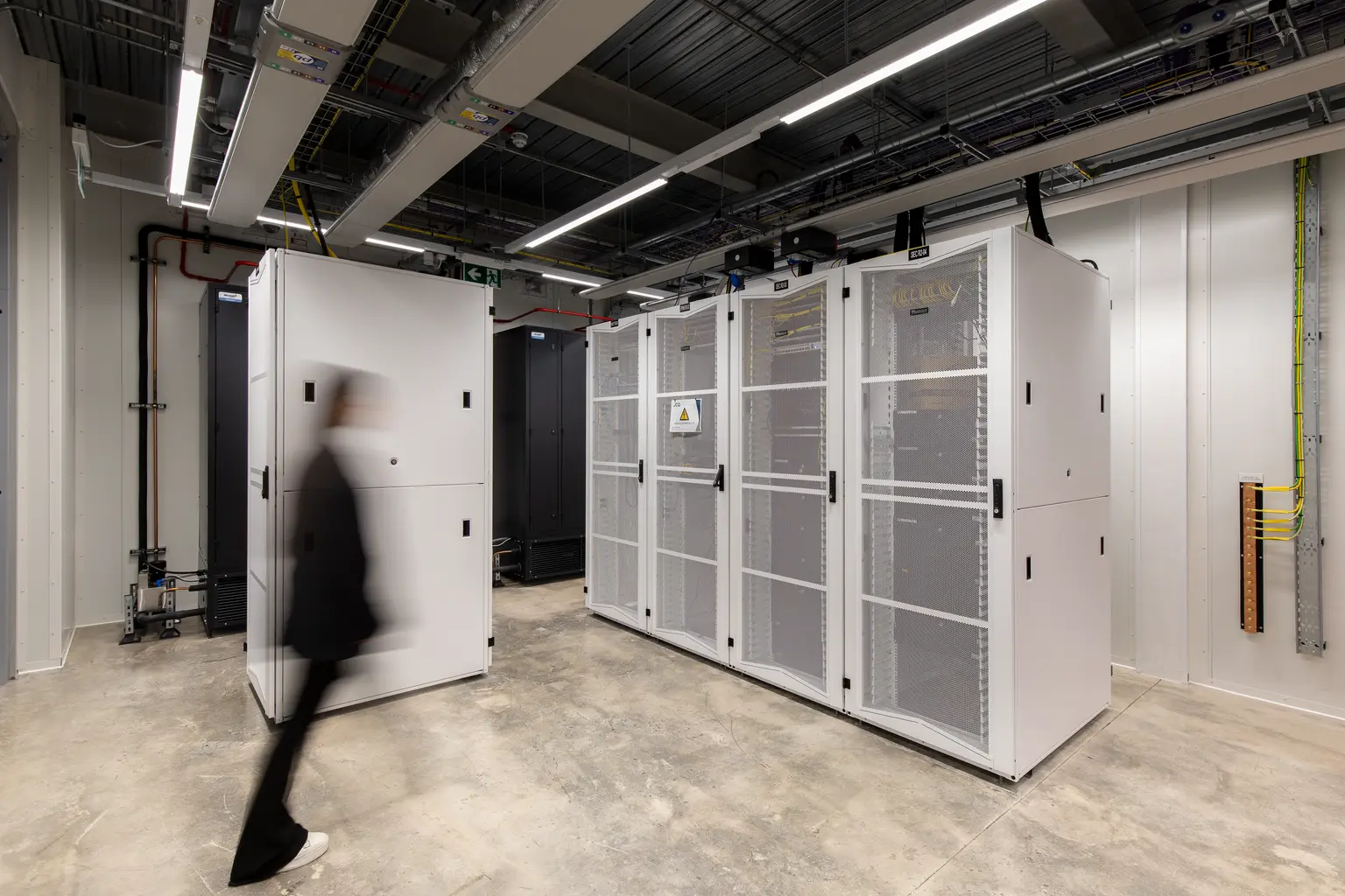 Vista interna del Kao Data Centre che mostra infrastrutture high-tech, rack per server e sistemi avanzati di raffreddamento e illuminazione.