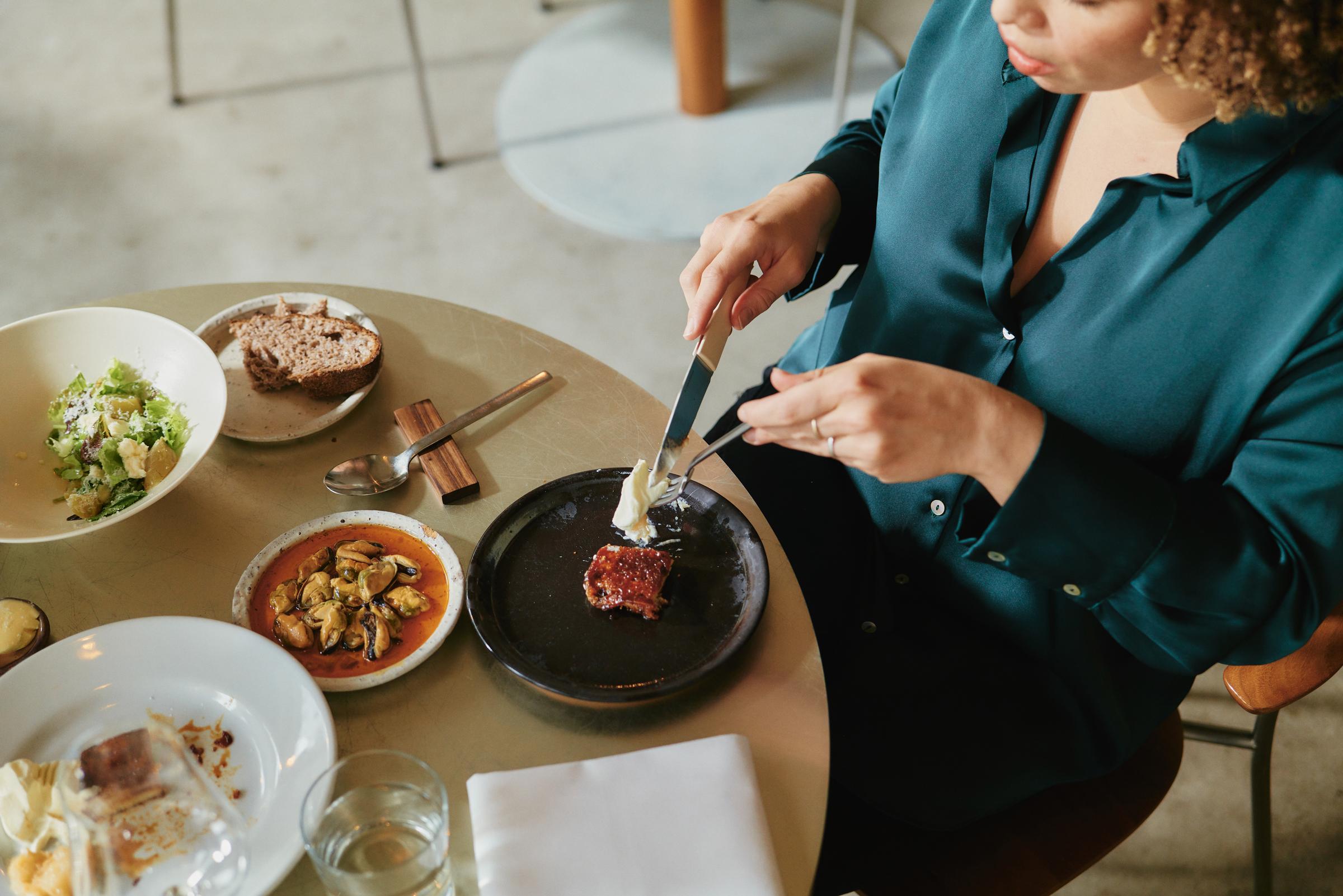 Una donna in un ristorante che gusta un pasto a un tavolo.