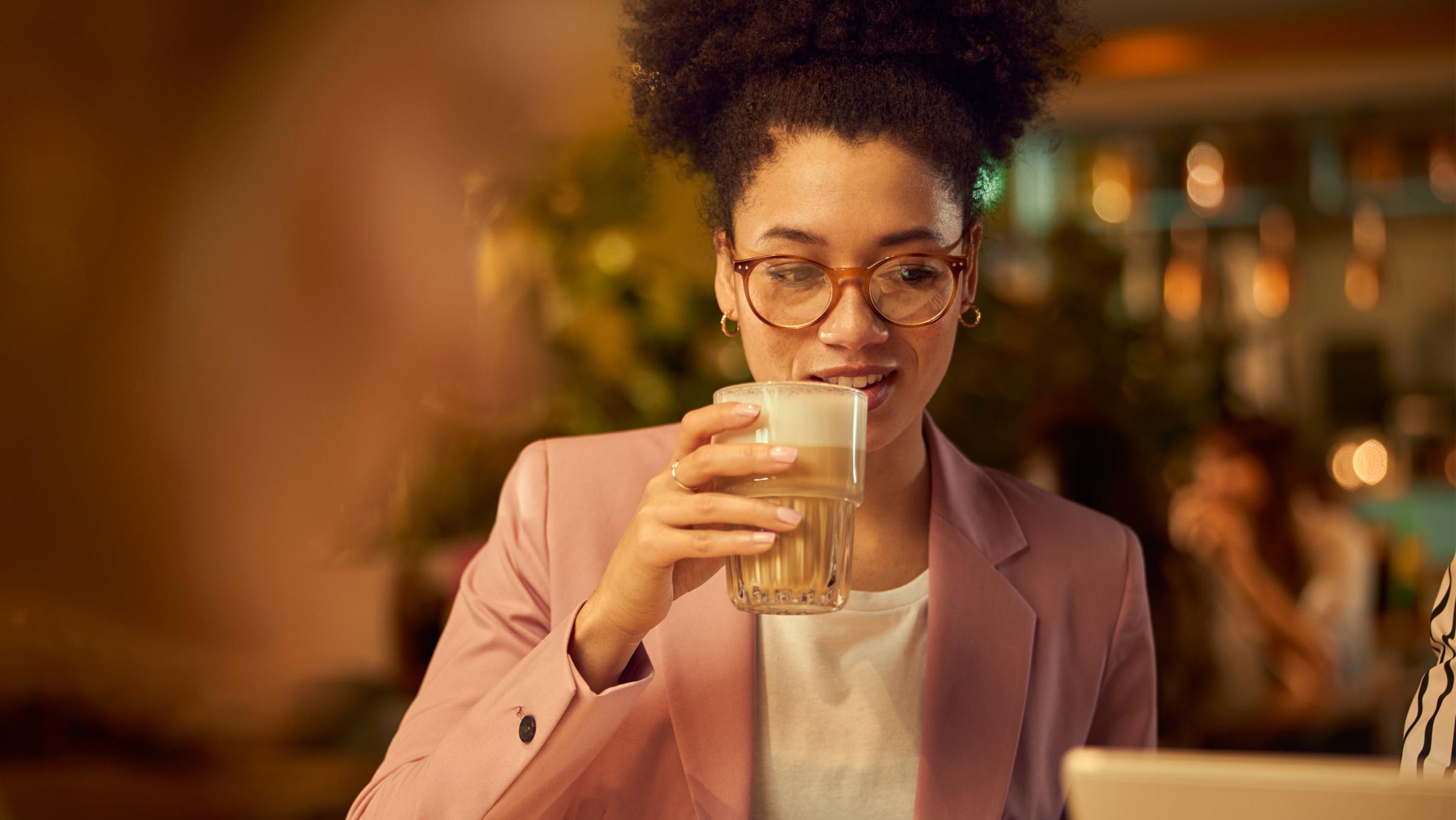Woman enjoying a drink at a cozy cafe.