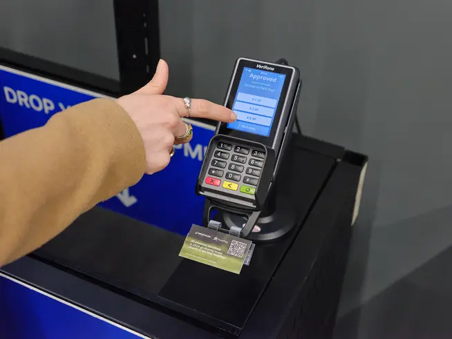 A customer at a Decathlon store checkout making a donation to ParkPlay using Adyen's P400 Plus terminal.