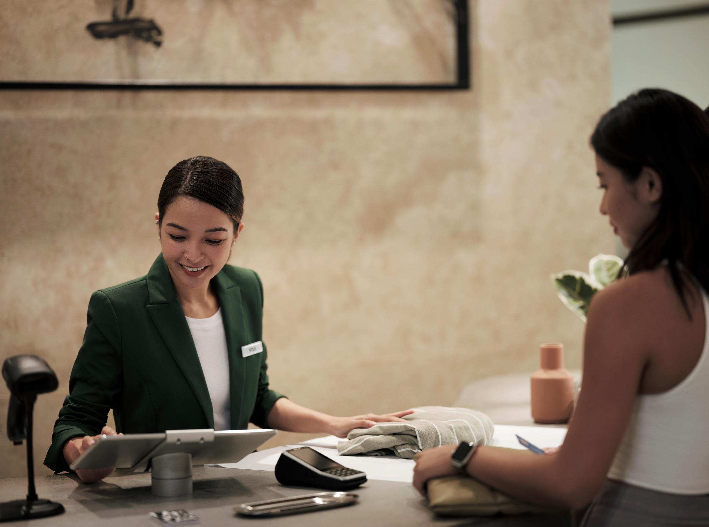 Woman shopping and paying inside a clothing and fashion store for apparel.