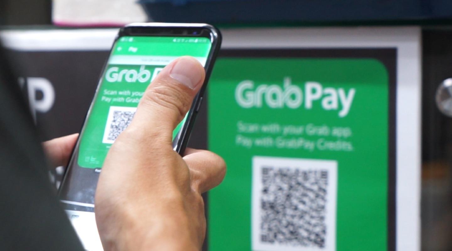 Person using a smartphone to scan a GrabPay QR code for payment